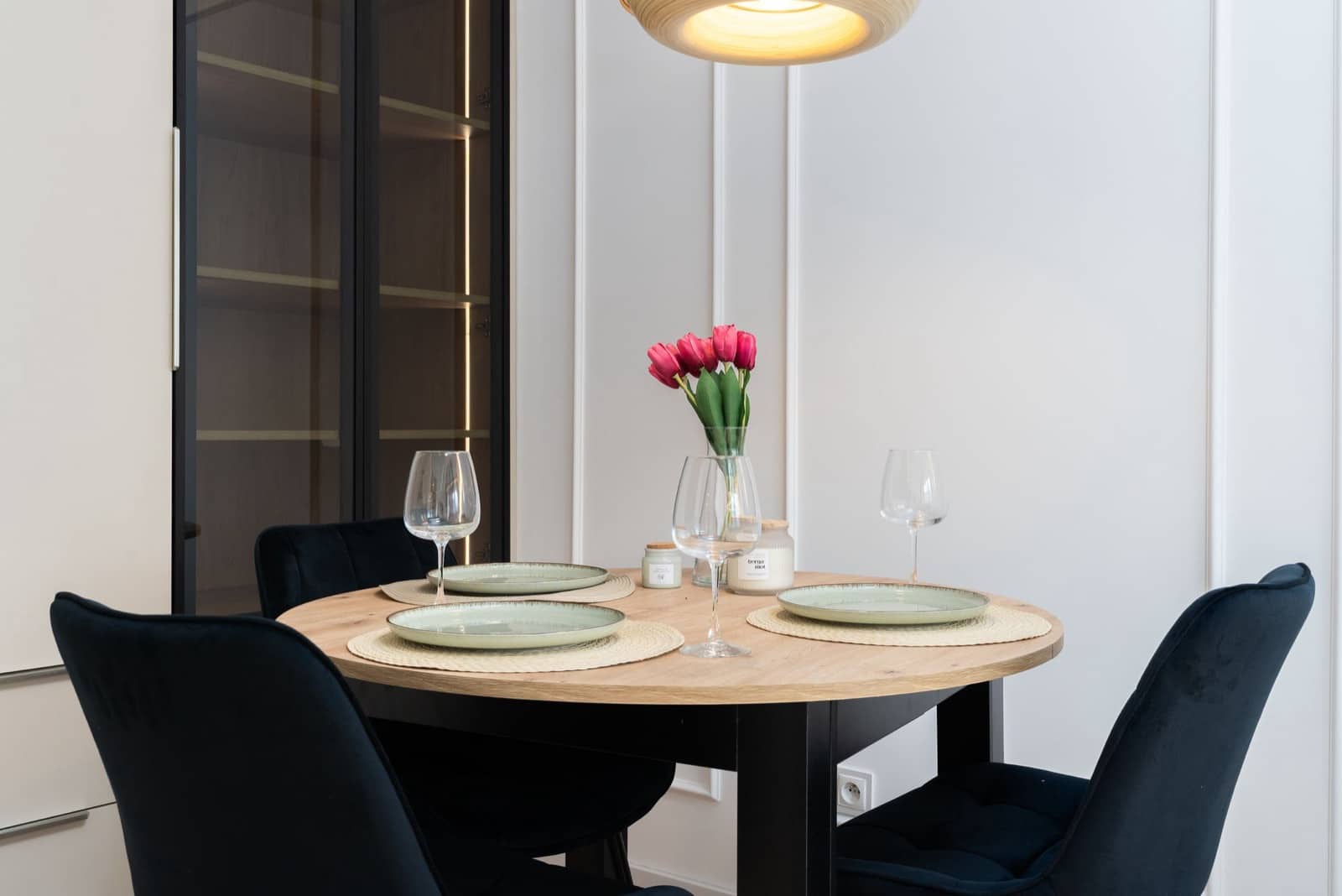 A dining table set with plates and glasses, tidy and ready